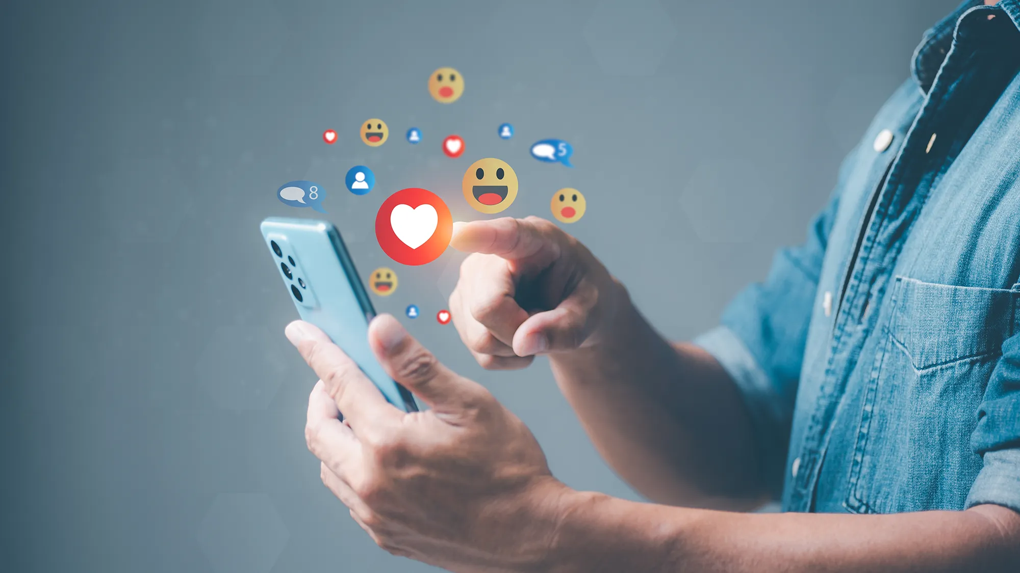 Un homme sur son téléphone qui consulte les médias sociaux de ses marques préférées avec des emojis autour du téléphone.
