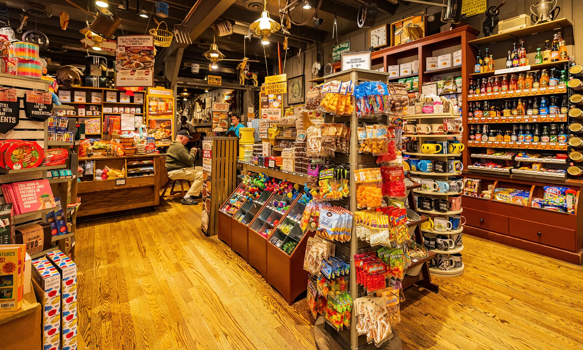 Intérieur d’une boutique Cracker Barrel avec étagères de friandises, jouets rétro, boissons et souvenirs variés.